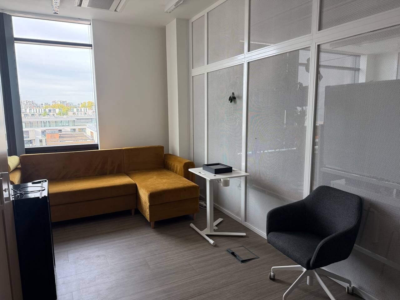 Room with a yellow corner sofa, an armchair and a window