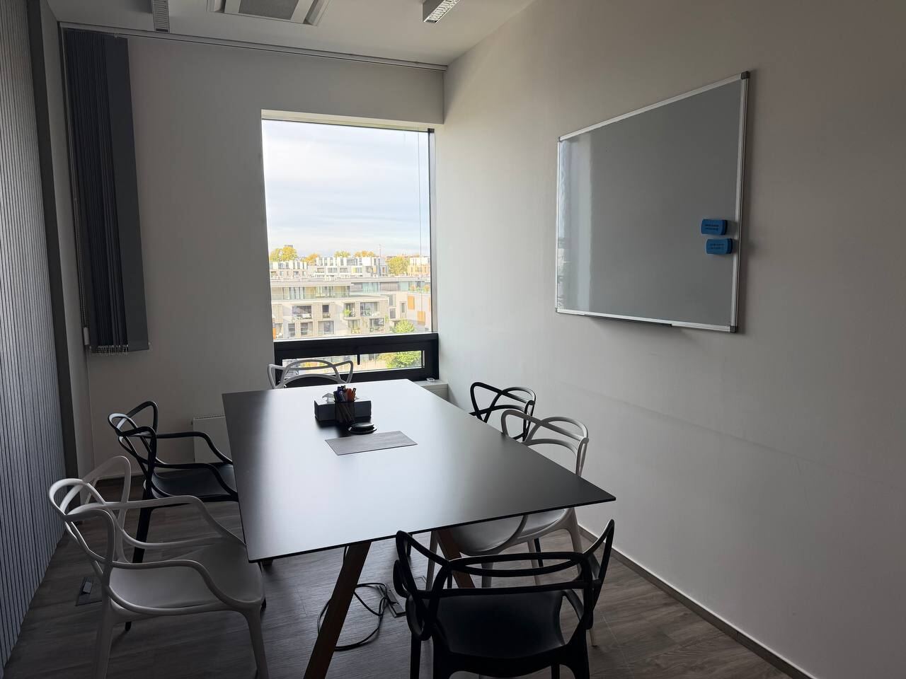 Small meeting room with a table, four chairs, a whiteboard and a window